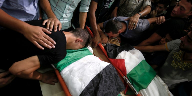 EDITORS NOTE: Graphic content / Relatives and mourners bid farewell to the bodies of Palestinian teenagers Amir Al-Namira (L) and Louai Kaheel (R) during their funeral at a mosque in Gaza City on July 15, 2018, after they were killed in an Israeli air strike the day before. - Aged 15 and 16, two Palestinians were on a road west of Gaza City when an air strike struck a nearby empty building, the enclave's health ministry said. Israel unleashed a wave of strikes against Gaza on July 14, while scores of rockets were fired back across the border from the territory. (Photo by SAID KHATIB / AFP)        (Photo credit should read SAID KHATIB/AFP/Getty Images)