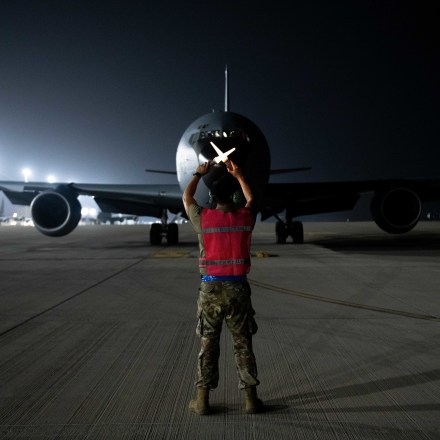 U.S. Air Force Senior Airman Jesse Lookingglass, a maintainer with the 379th Expeditionary Aircraft Maintenance Squadron, guides a KC-135 into a parking spot on Al Udeid Air Base, Qatar, Aug. 1, 2022. After landing, the aircraft taxis to the ramp, where any required maintenance is performed. (U.S. Air National Guard photo by Airman 1st Class Constantine Bambakidis)