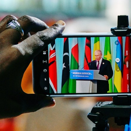 Russian President Vladimir Putin is seen on a phone screen as he attends a joint statement with President of Comoros Azali Assoumani at the Russia Africa Summit in St. Petersburg, Russia, Friday, July 28, 2023. (Pavel Bednyakov, Sputnik, Kremlin Pool Photo via AP)