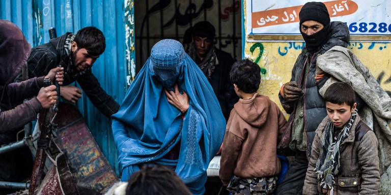 People wait to receive aid provided by a charity on the outskirts of Kabul on January 30, 2022.. (Photo by Wakil KOHSAR / AFP) (Photo by WAKIL KOHSAR/AFP via Getty Images)