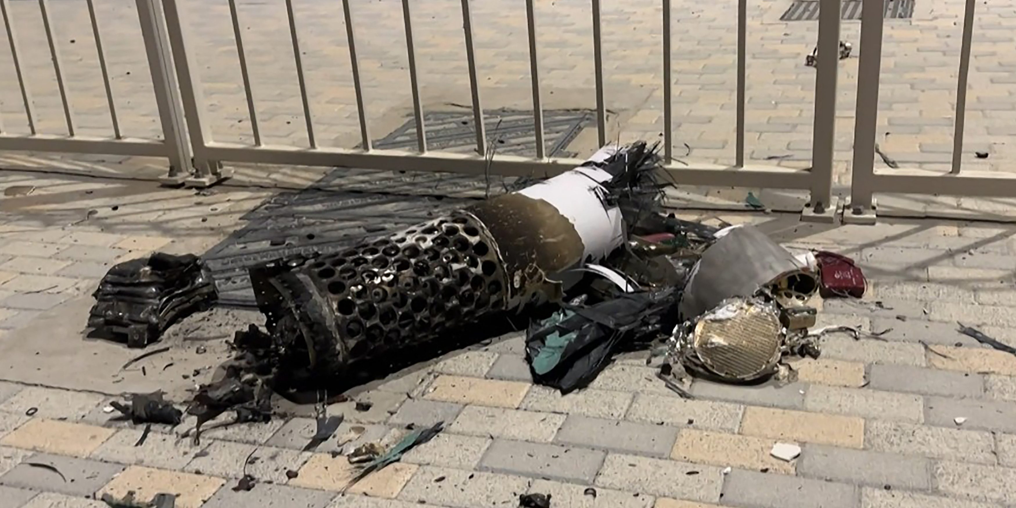 The remnants of an Iranian missile intercepted over Qatar, as it lies on a pavement near a fence on June 23, 2025.