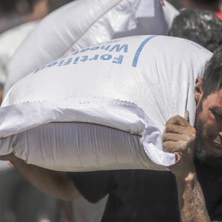 A man carries a flour sack from the World Health Organization warehouse, in Gaza City, Gaza on June 26, 2025.
