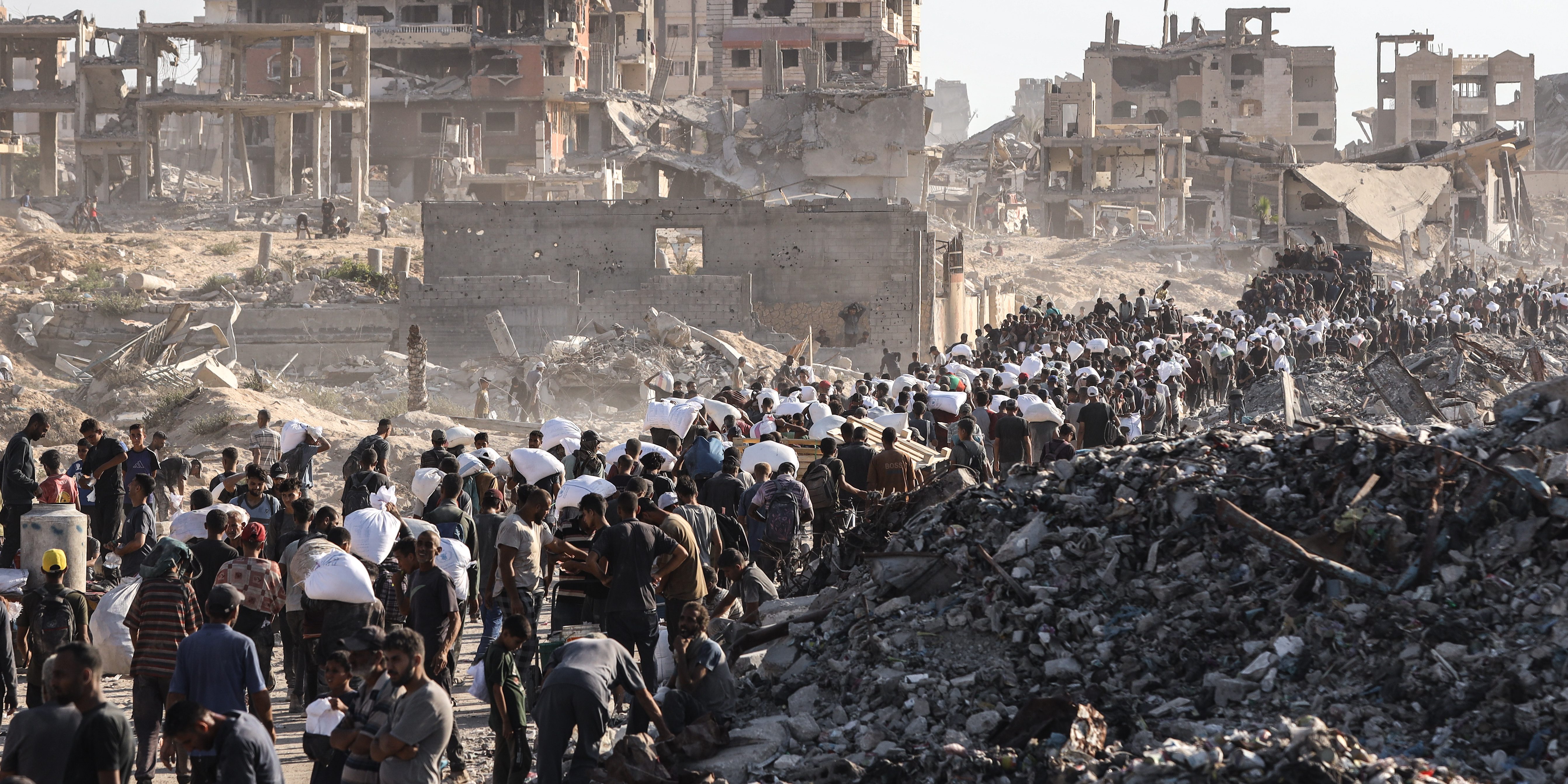 Palestinians suffering from extreme hunger under Israel's intense attacks and blockade gather at an aid distribution center near the Zikim border crossing in Gaza to access limited food on August 03, 2025.