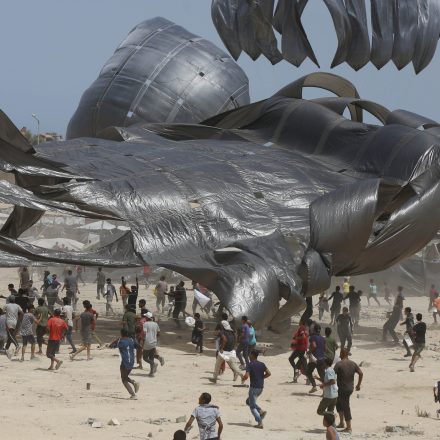 DEIR AL BALAH, GAZA - AUGUST 19: Palestinians flock to the area where aircrafts drop humanitarian aid supplies via parachutes in Deir al Balah, Gaza on August 19, 2025. (Photo by Mohammed Nassar/Anadolu via Getty Images)