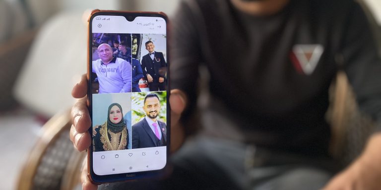 Ramez Abu Nasser displays photos of his parents and two brothers who were killed in an Israeli strike, on November 4, 2024.